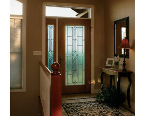 Home entryway with a front door that has decorative glass inserts 