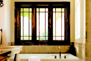 A brown framed window installed in the bathroom above a tub.