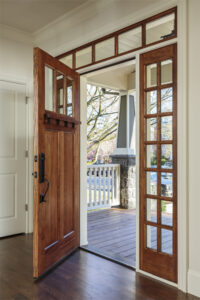 Open wood front entry door leading out to a front porch 
